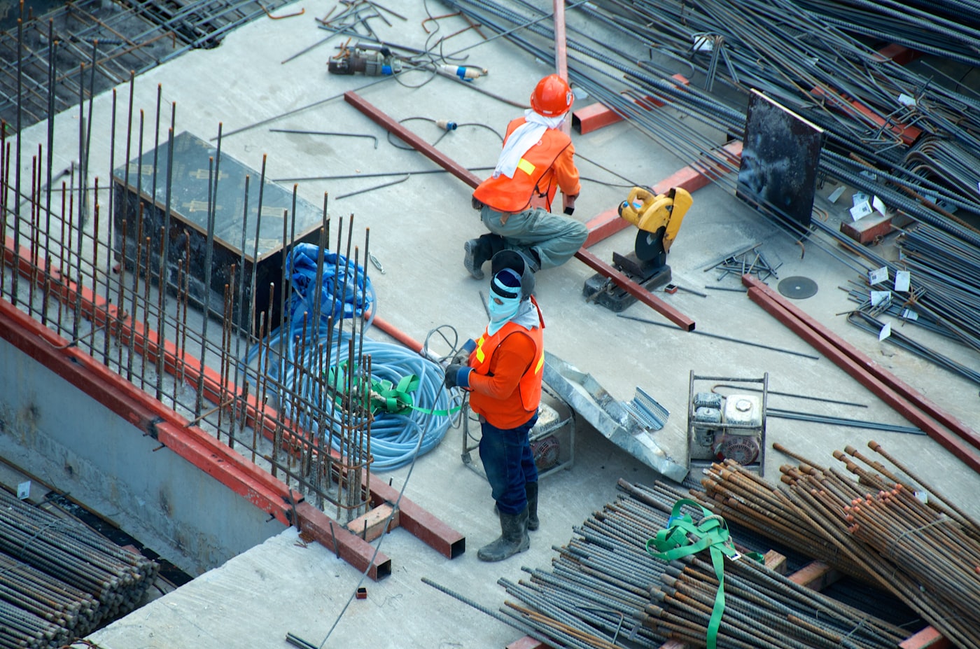 Busy concrete construction site with rebar cages, formwork and on-site cutting